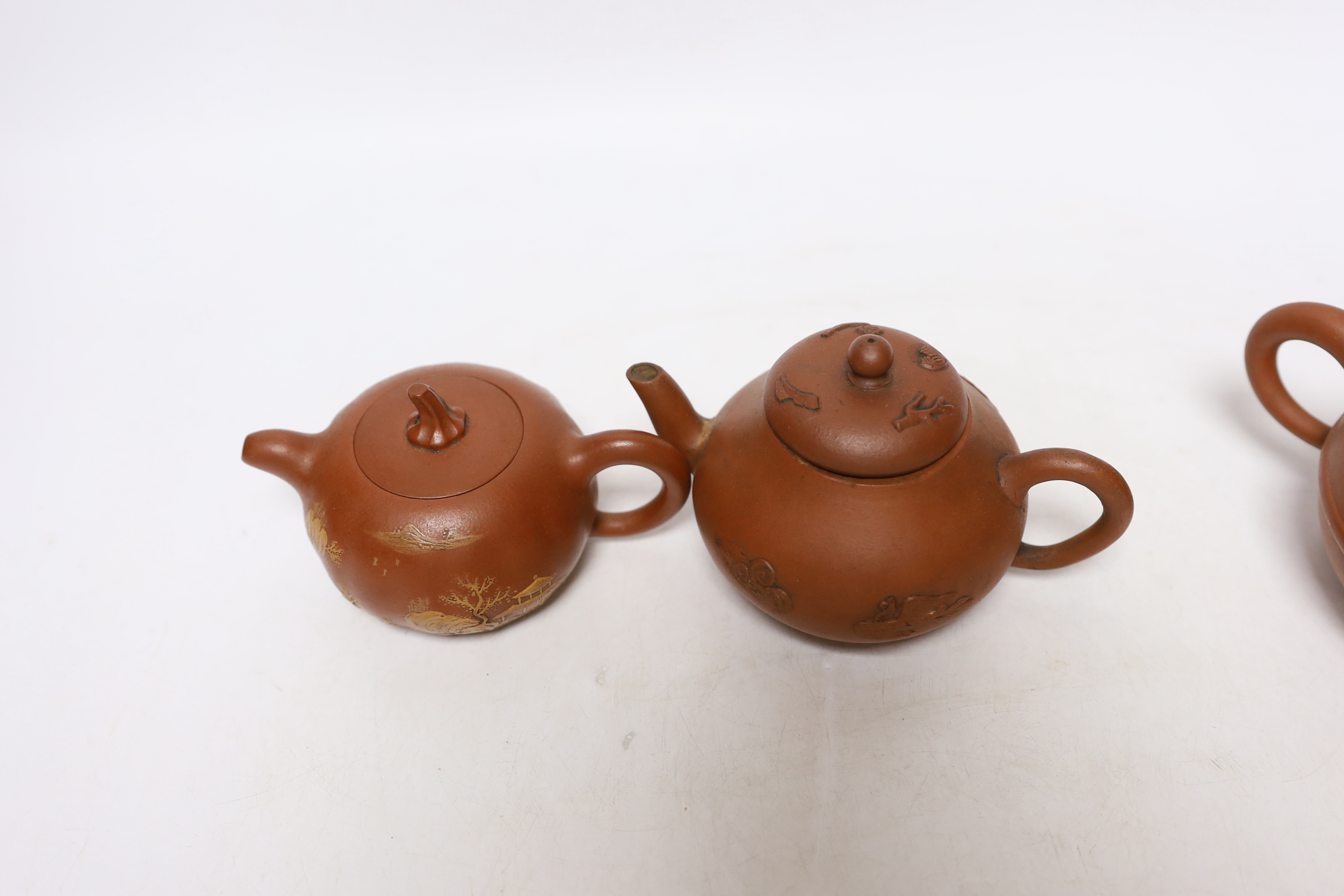 Four Chinese Yixing teapots, one slip decorated with a landscape, tallest 10.5cm